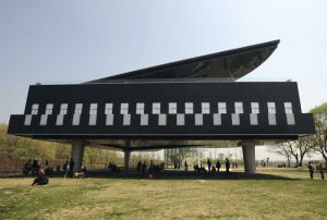 Visitors gather in front of and below a piano-shaped building in Huainan