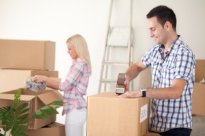 young couple packing moving boxes, ready for move out